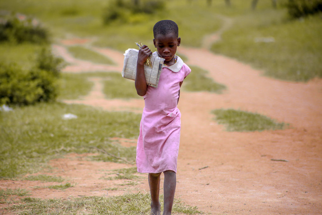 girl walking to class on a path