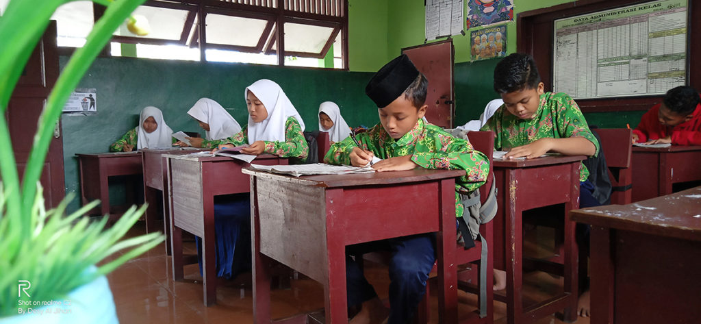 kids sitting down at desks writing