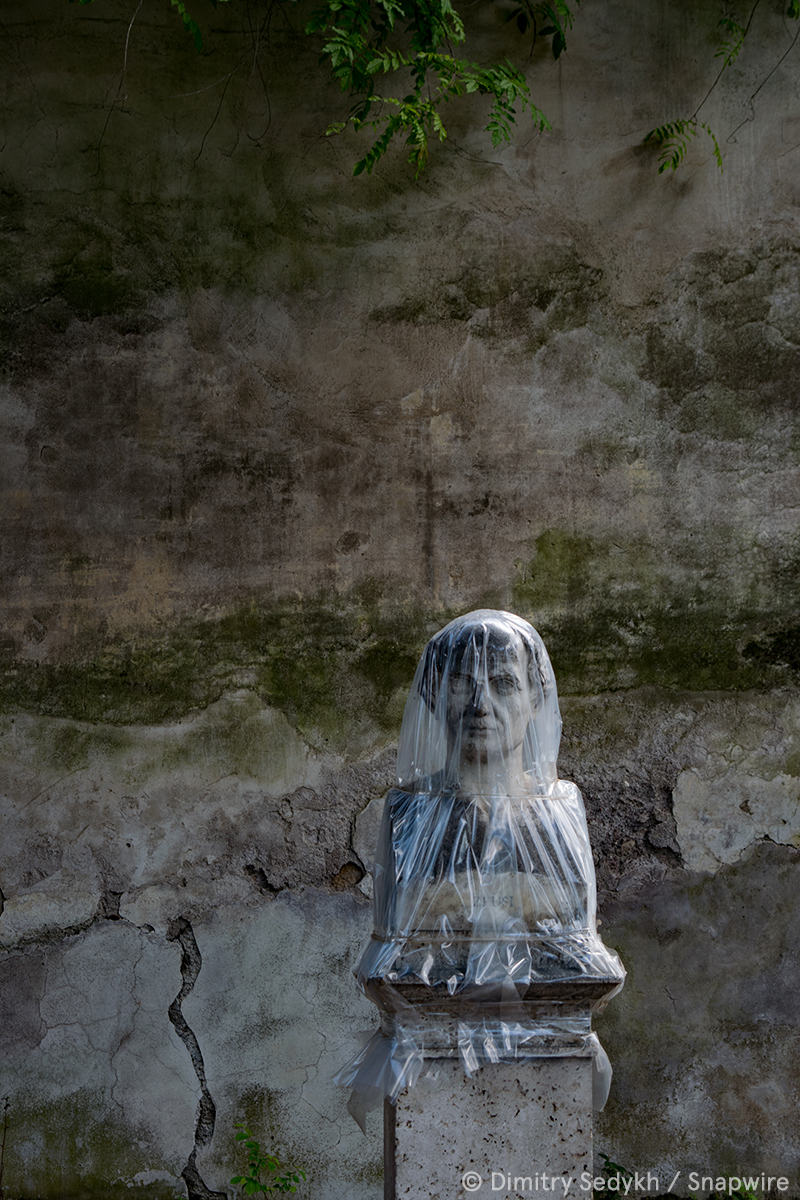 granite statue with a plastic bag over its head