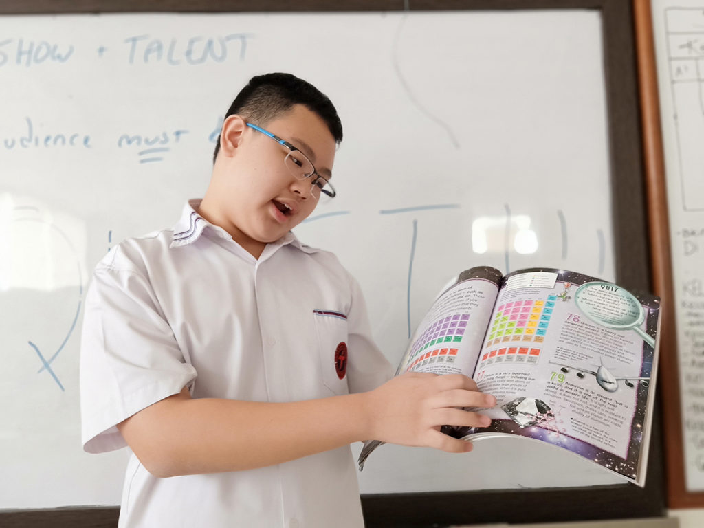 boy showing something in a book