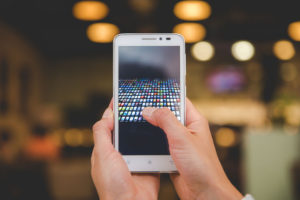 female hands holding a smartphone with apps on screen