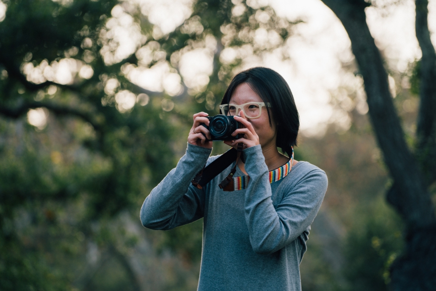 girl with glasses holding a camera up to her face