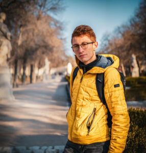 Headshot of man outdoors staring at camera