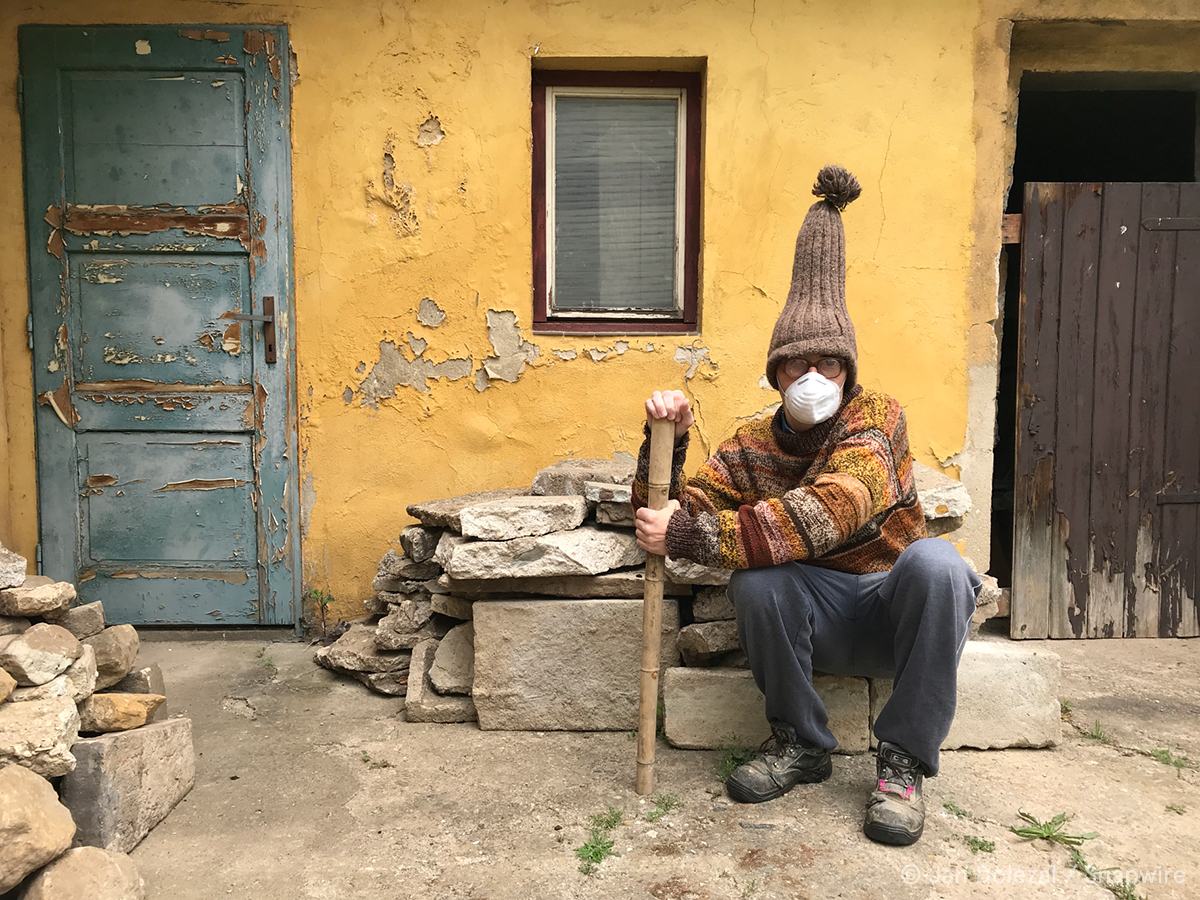 man with a really beanie hat holding a bamboo stick