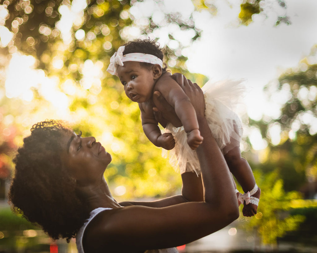 portrait woman holding baby up