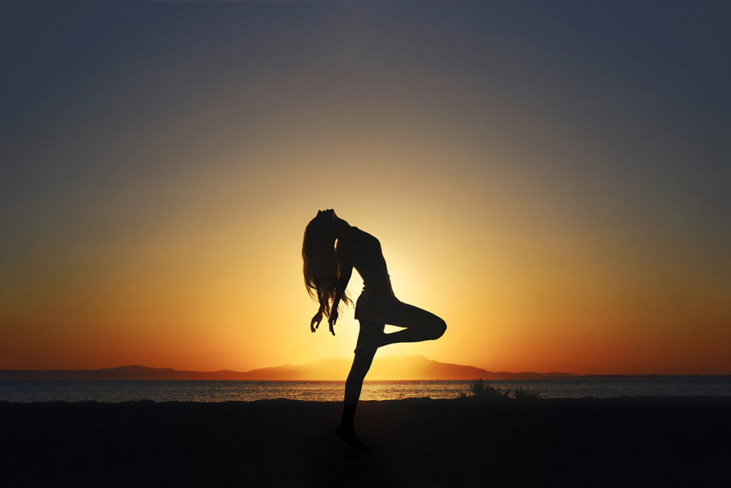 person on the beach with the sun behind them dramatic ligthting