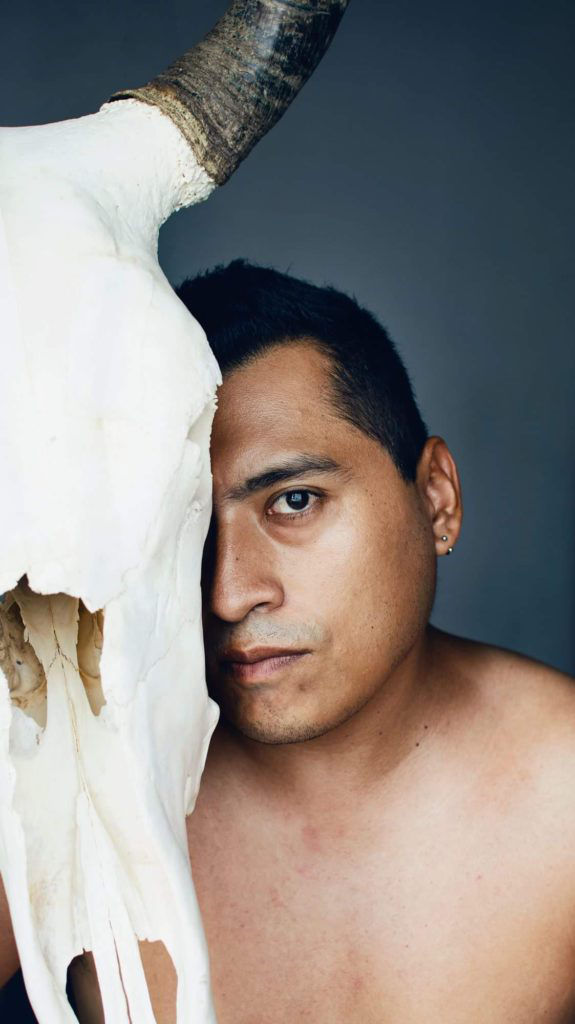 man posing with an animal skull