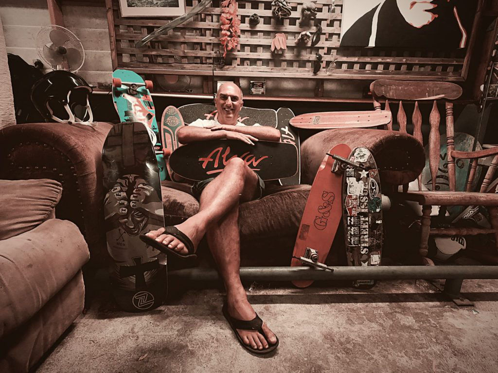 man sitting on the couch with his skateboards