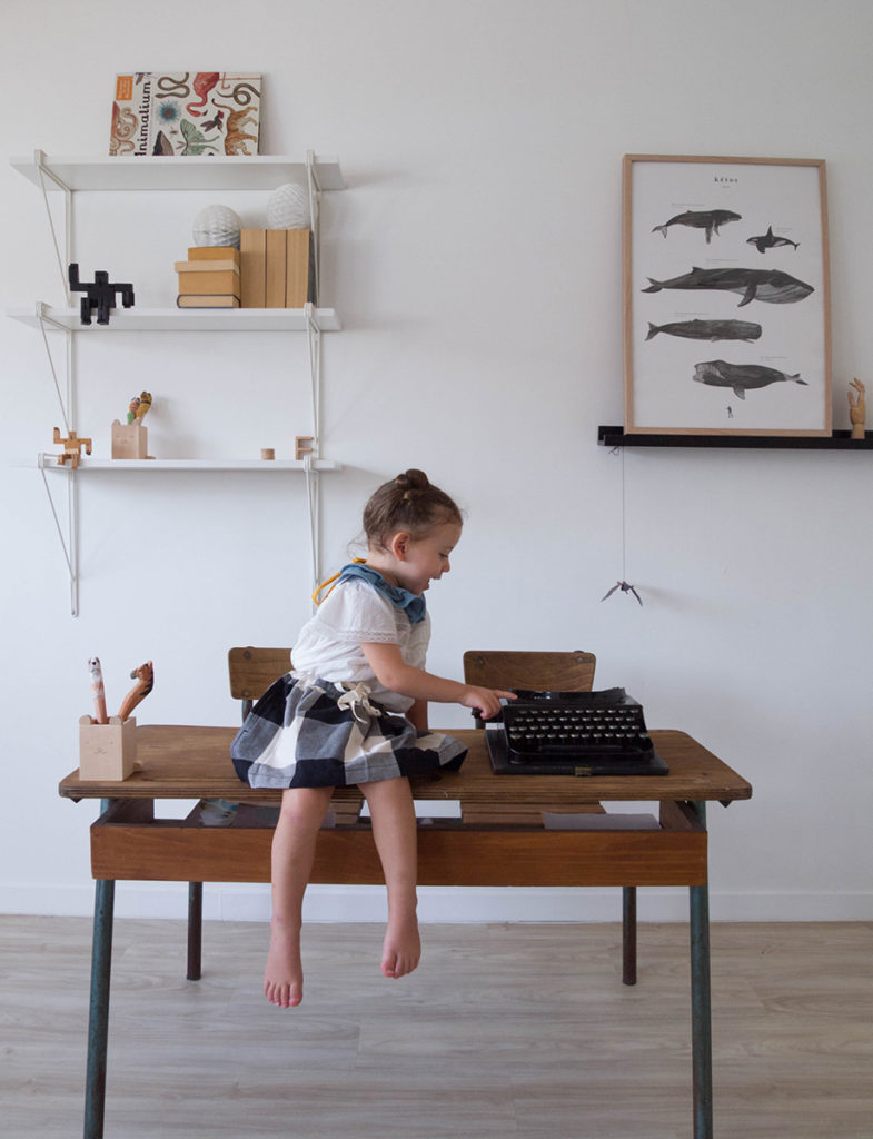 little girl sitting on a desk