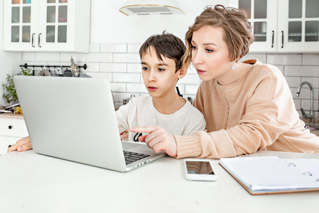 mother teaching son on a computer