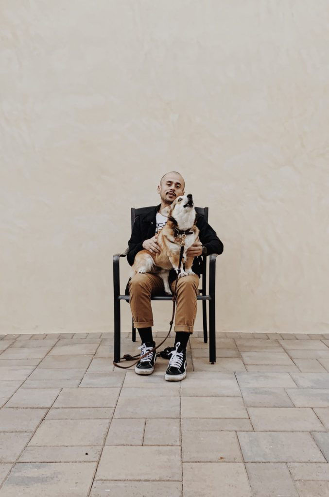 portrait of a man sitting in a chair with his dog