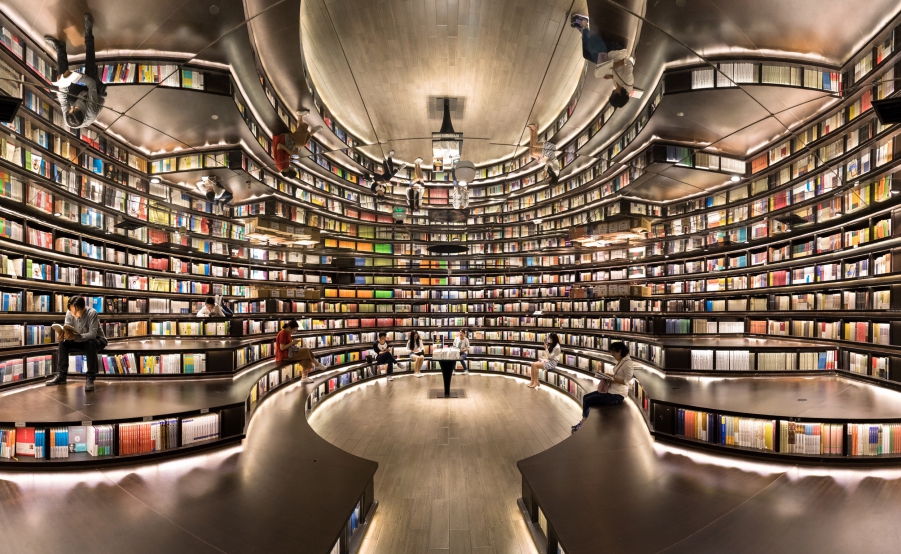 Library filled with books and lights with a reflective mirror on the ceiling