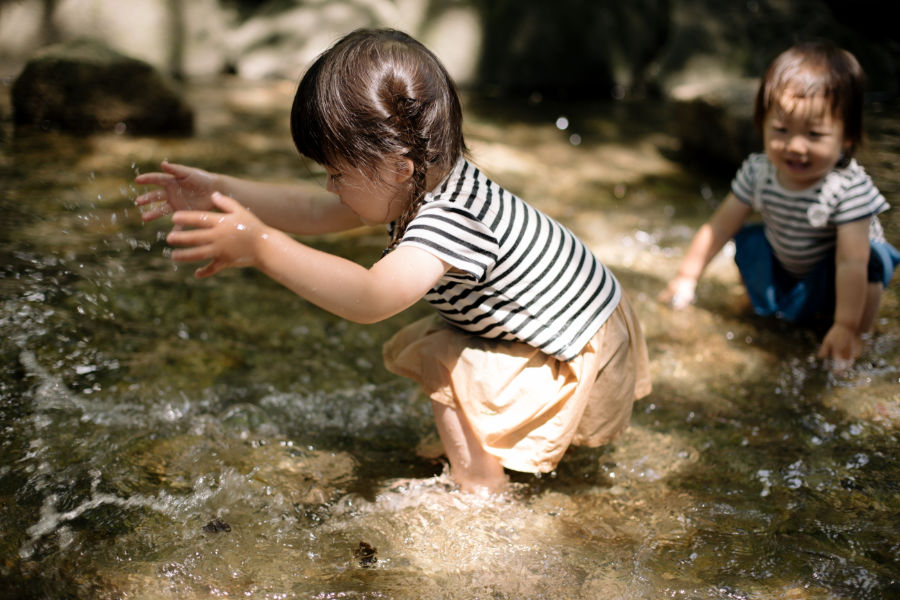 Two Asian girls playing in a stream