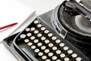 Close up of typewriter with pen and paper in the back