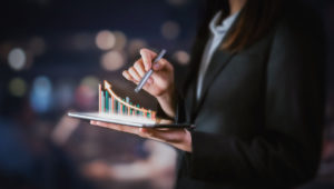 woman holding a tablet with digital growth graphic